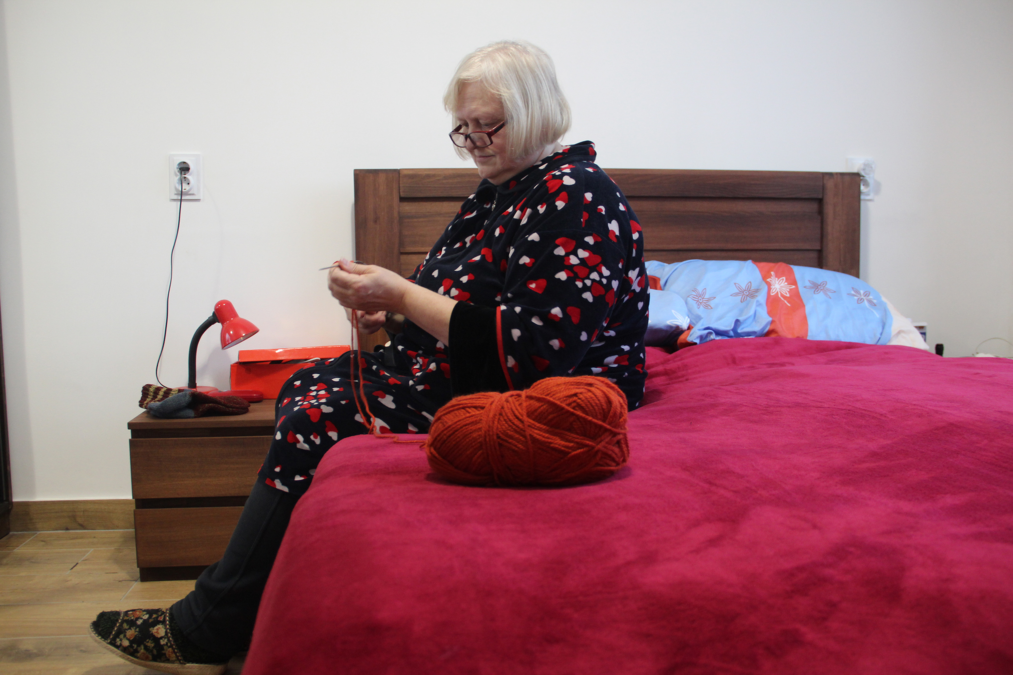 Мешканка прихистку у своїй кімнаті плете теплі шкарпетки