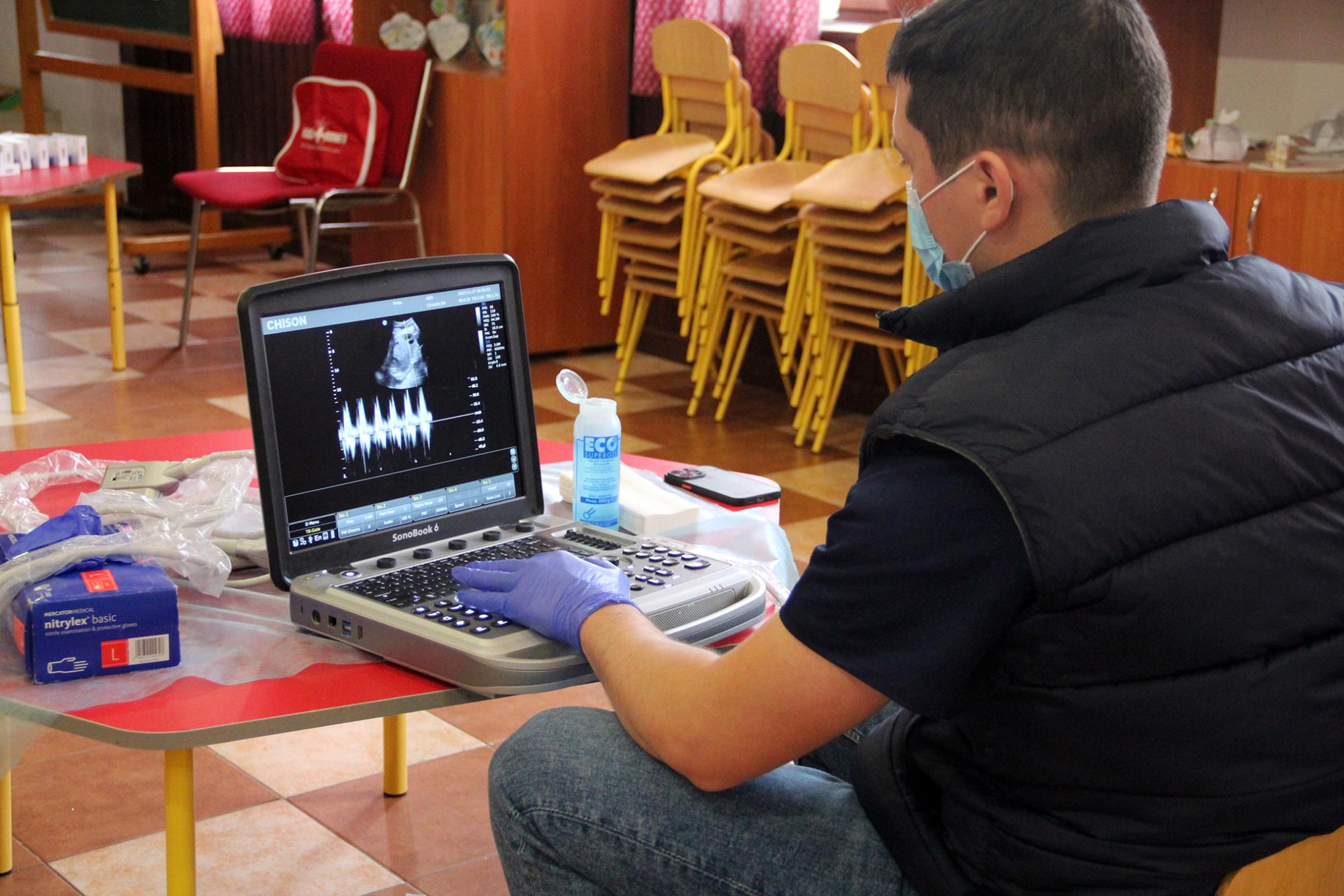 Лікар за допомогою обладнання досліджує стан дитини у вагітної жінки