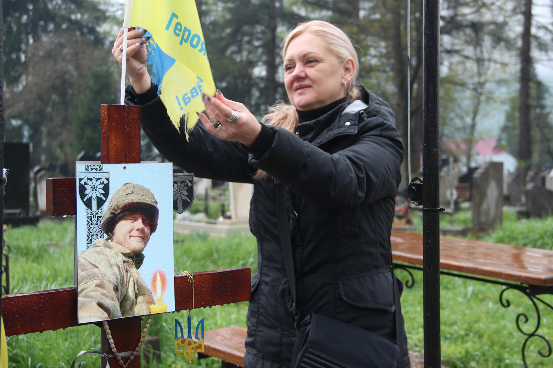 Мама Андрія Костика поправляє прапор на його могилі