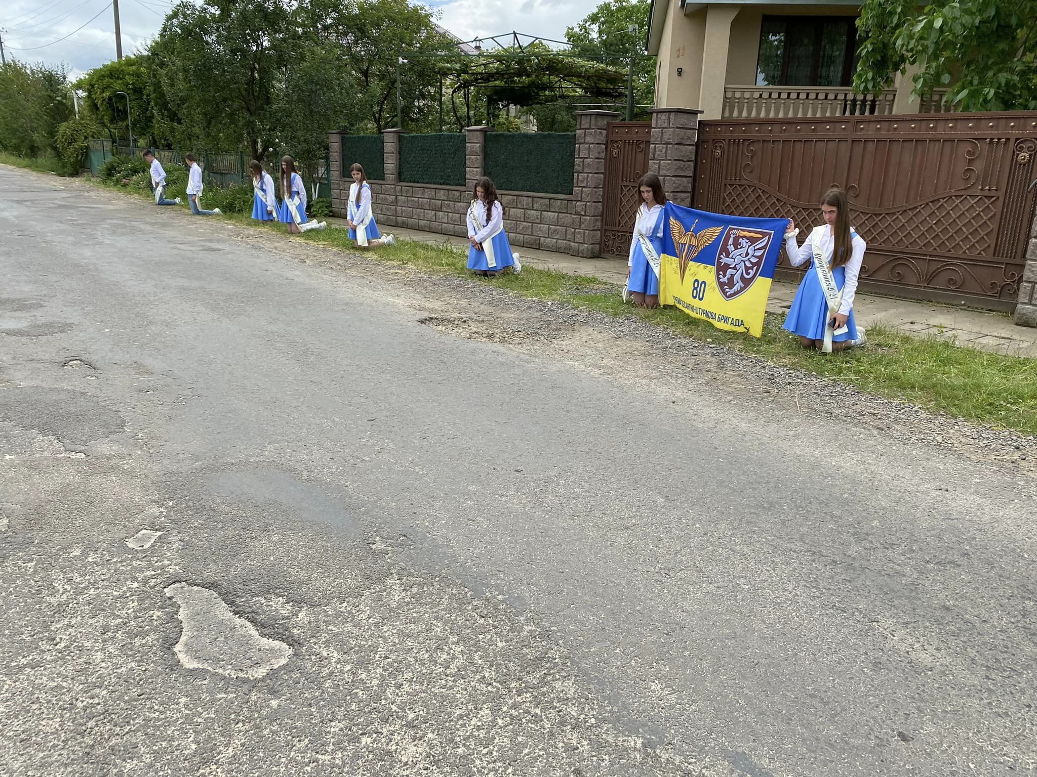 Випускники місцевої школи навколішки зустрічають полеглого Захисника 