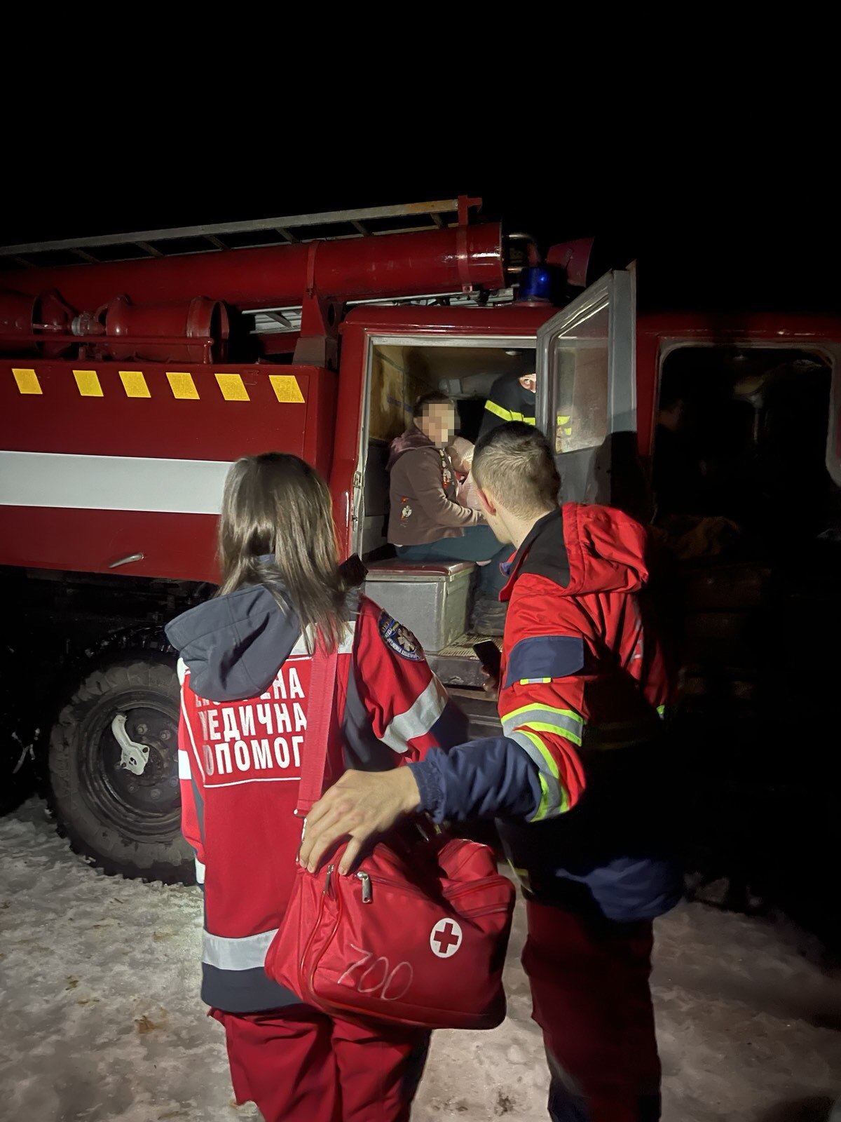 Бригада медиків біля пожежної машини, яка їх доправила до місця виклику 