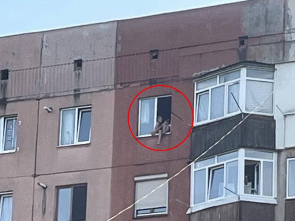 Дівчинка у вікні багатоповерхівки