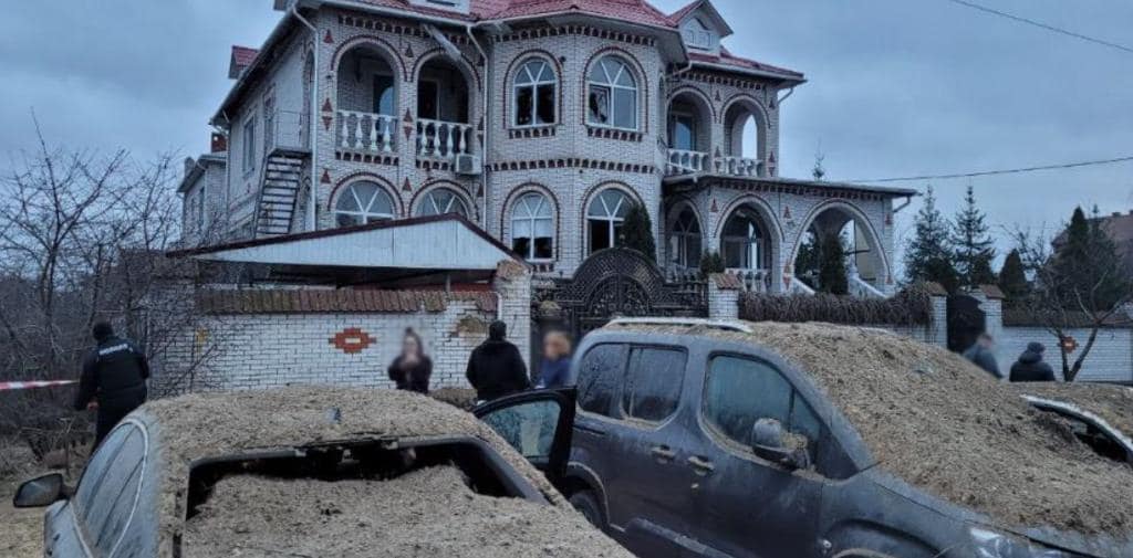 Пошкоджена будівля та припарковані біля неї авто 