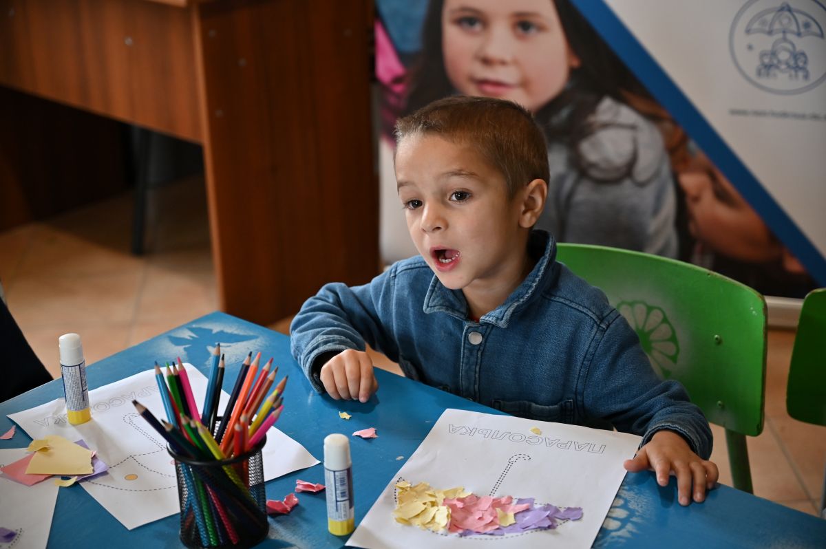 Хлопчик за ліпленням з паперу