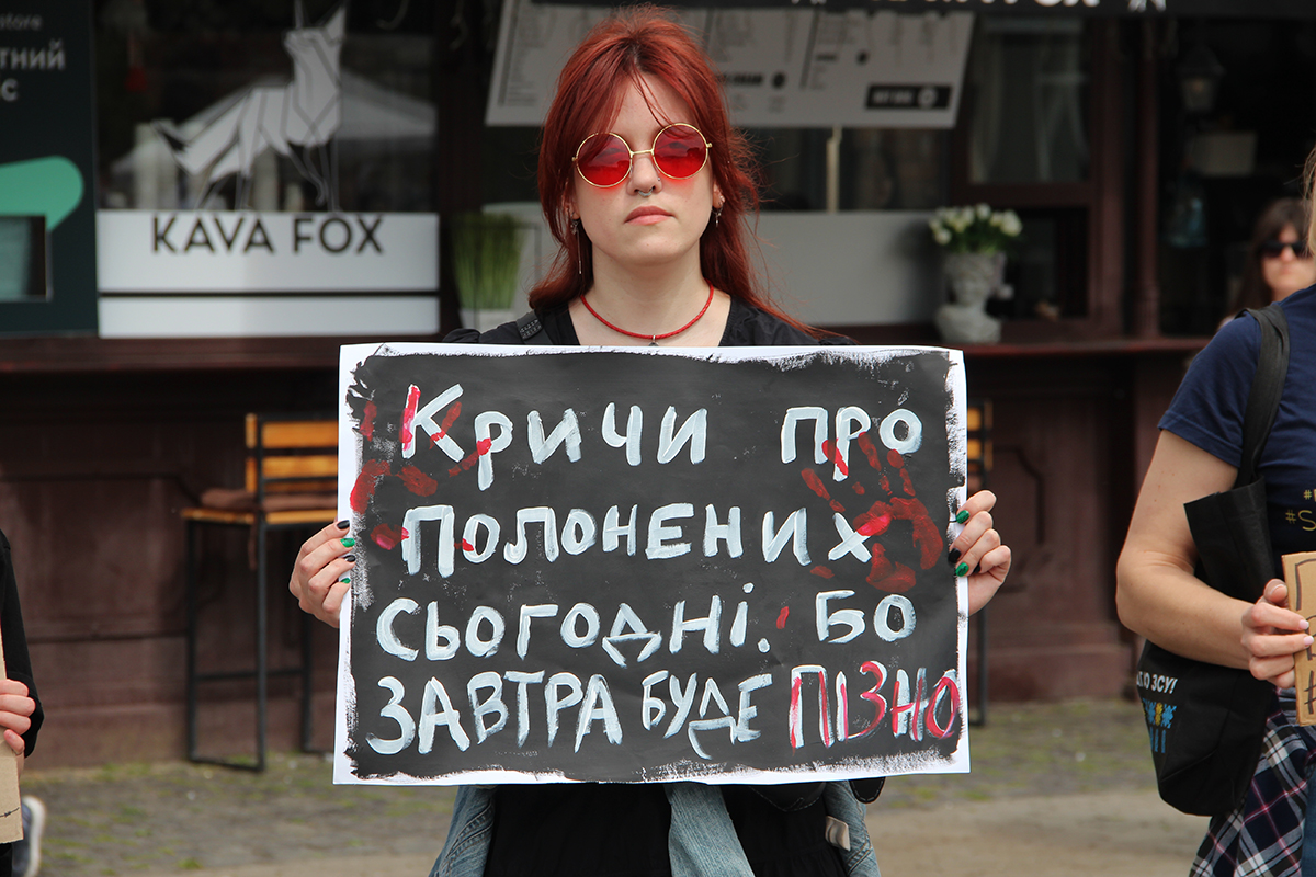 Дівчина з плакатом на підтримку військовополонених
