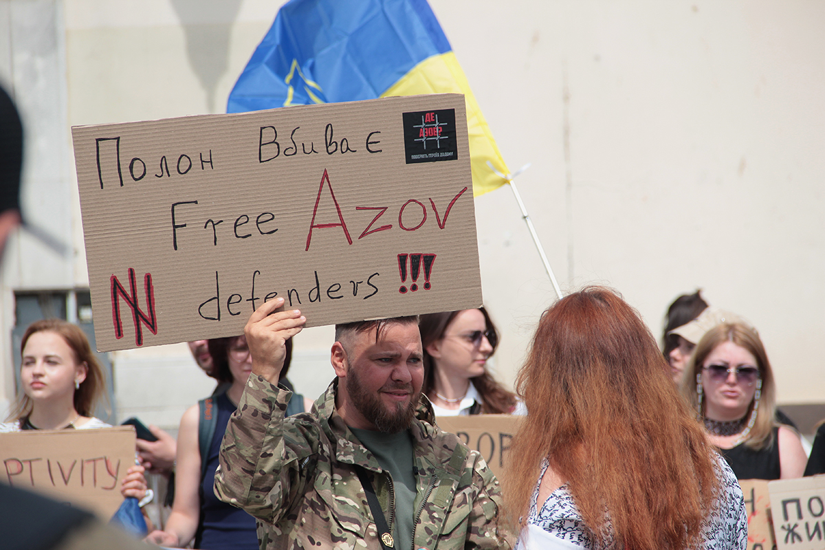 Військовий з плакатом на підтримку Азову
