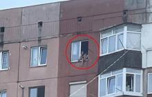 Дівчинка у вікні багатоповерхівки