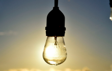 Електрична лампа на фоні сонця й неба