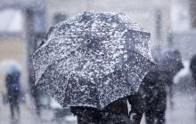 Сніг на парасольці пішохода. На Закарпатті оголосили про погіршення погоди